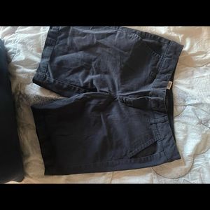Mid thigh length navy shorts.